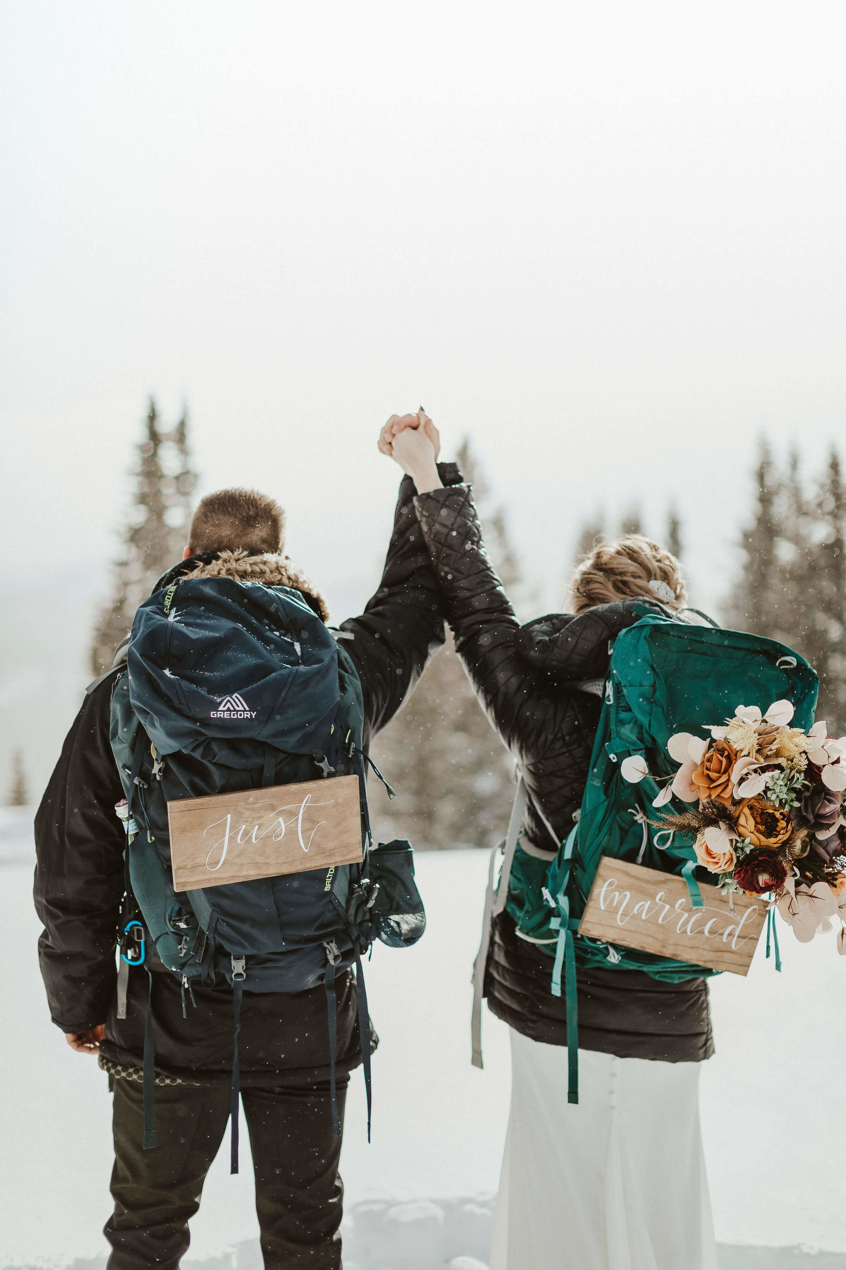couple eloping with backpacks & signs "just married" - how to make an elopement special