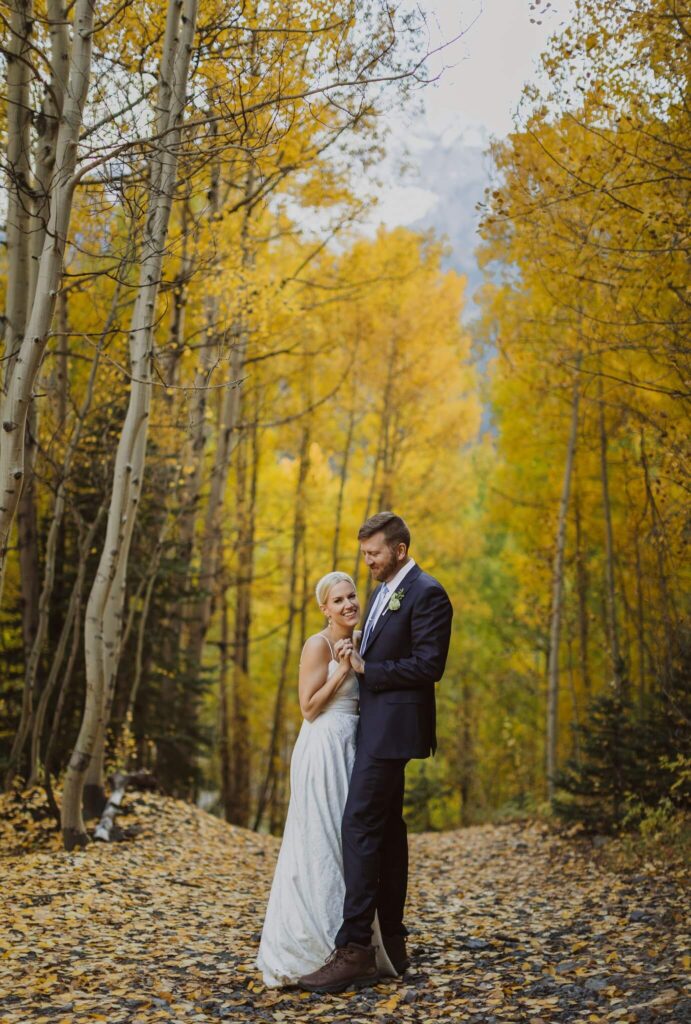 Bride and groom dancing surrounded by fall foliage for Telluride elopement