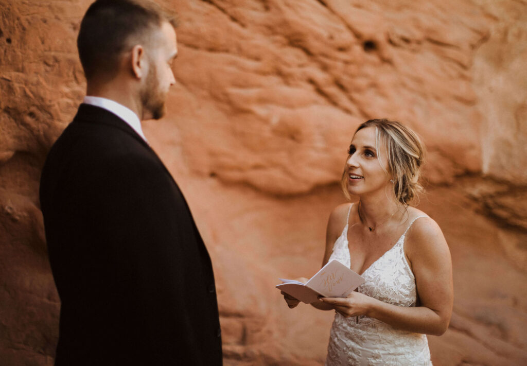 Bride reading vows to groom with red rock formation in the background