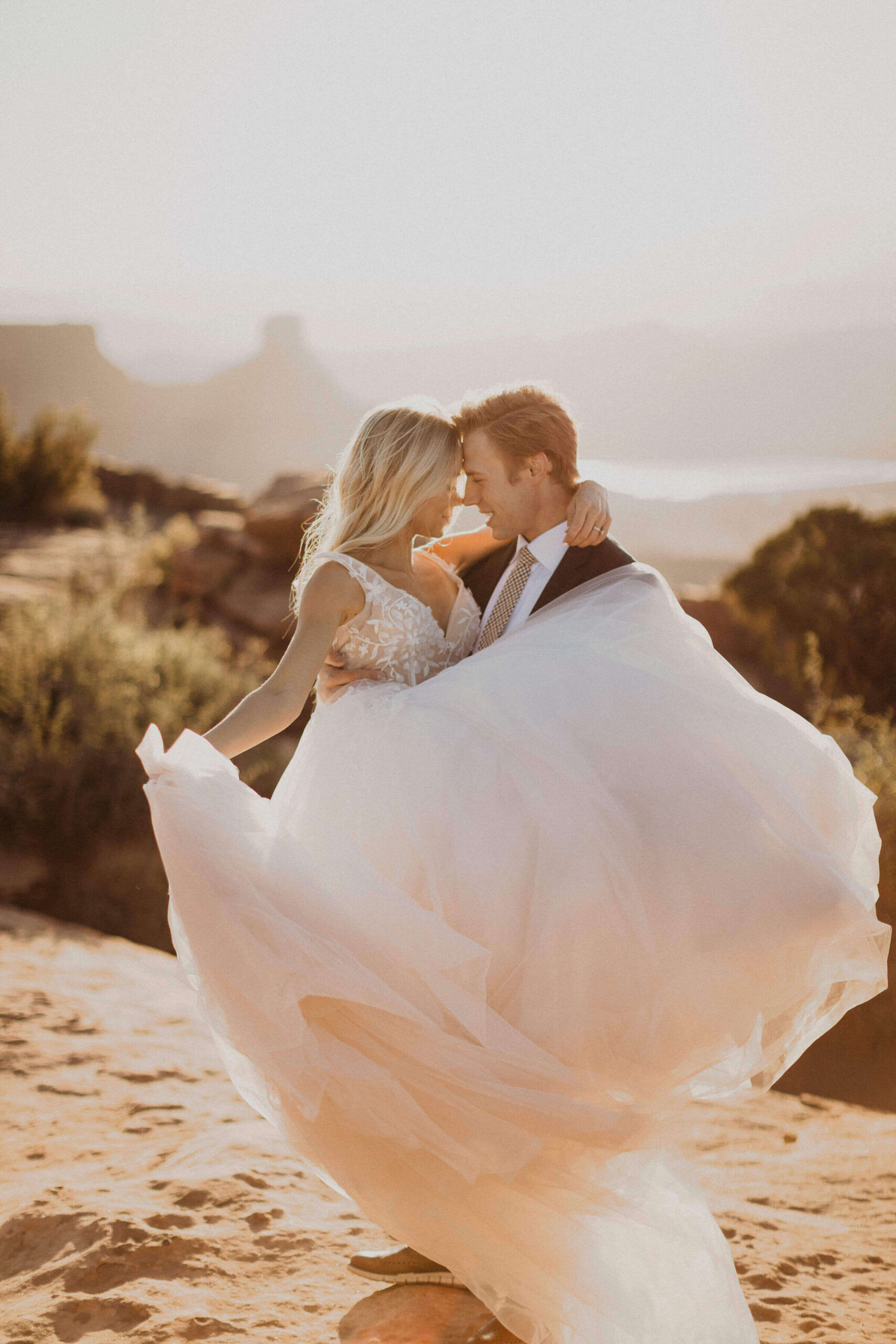 groom holding bride at elopement in Moab