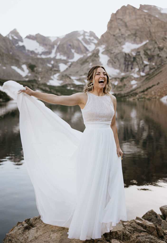 bride smiling and standing in front of Lake Isabelle