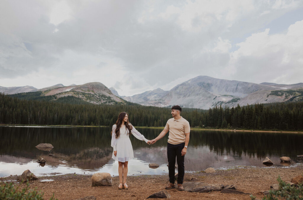 Bride and groom holding hands in front of mountains and Brainard Lake