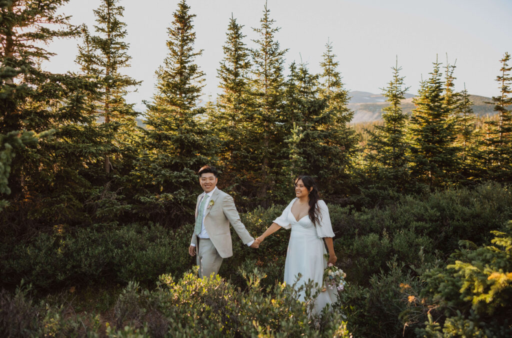 bride and groom walking surrounded by trees at Brainard Lake