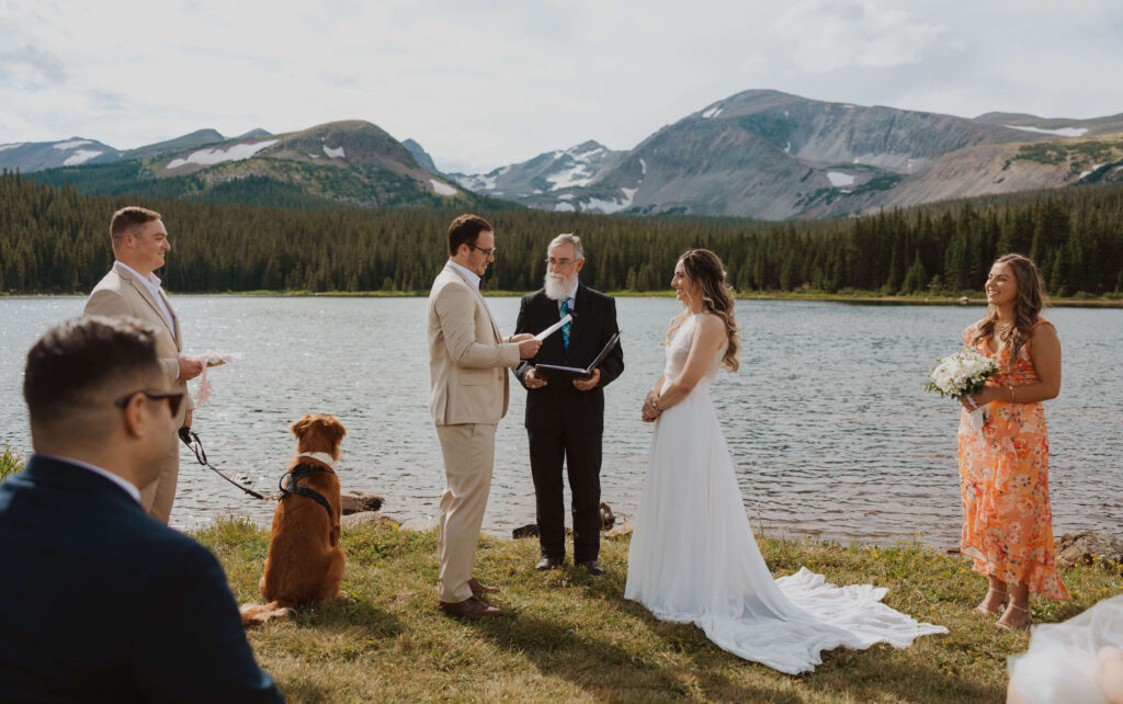 Couple getting married next to Brainard Lake backed by mountain scenery