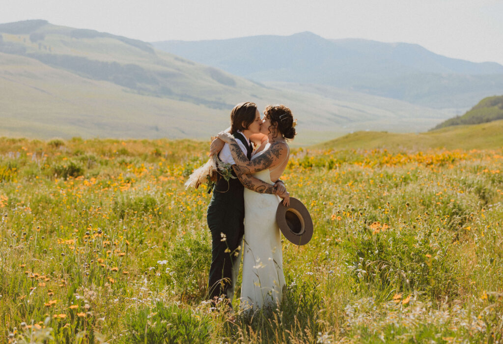 elopement couple embracing in a field of flowers for Colorado mountain elopement