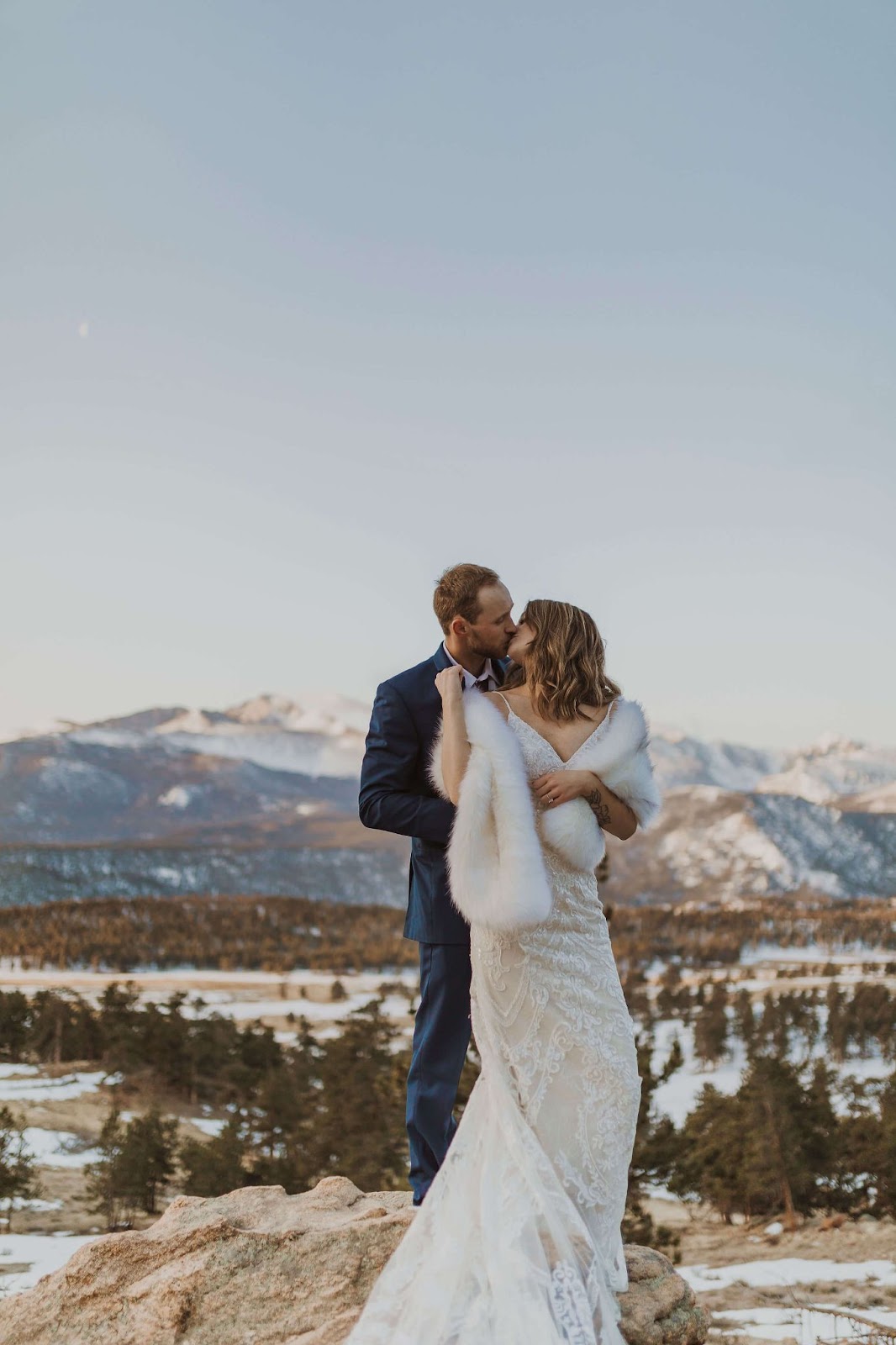couple posing and kissing for a snowy Rocky Mountain National Park elopement