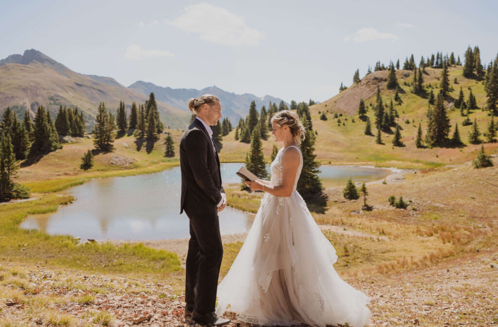 couple reading vows for Ouray elopement surrounded by mountains and trees