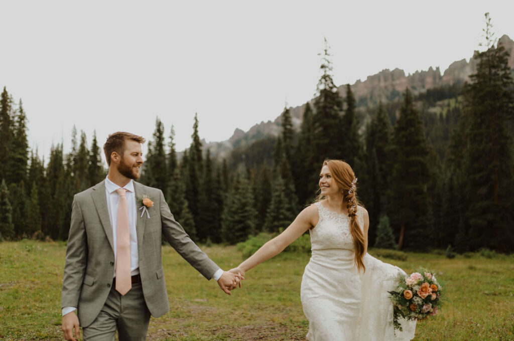 Ouray elopement couple holding hands and smiling at eachother