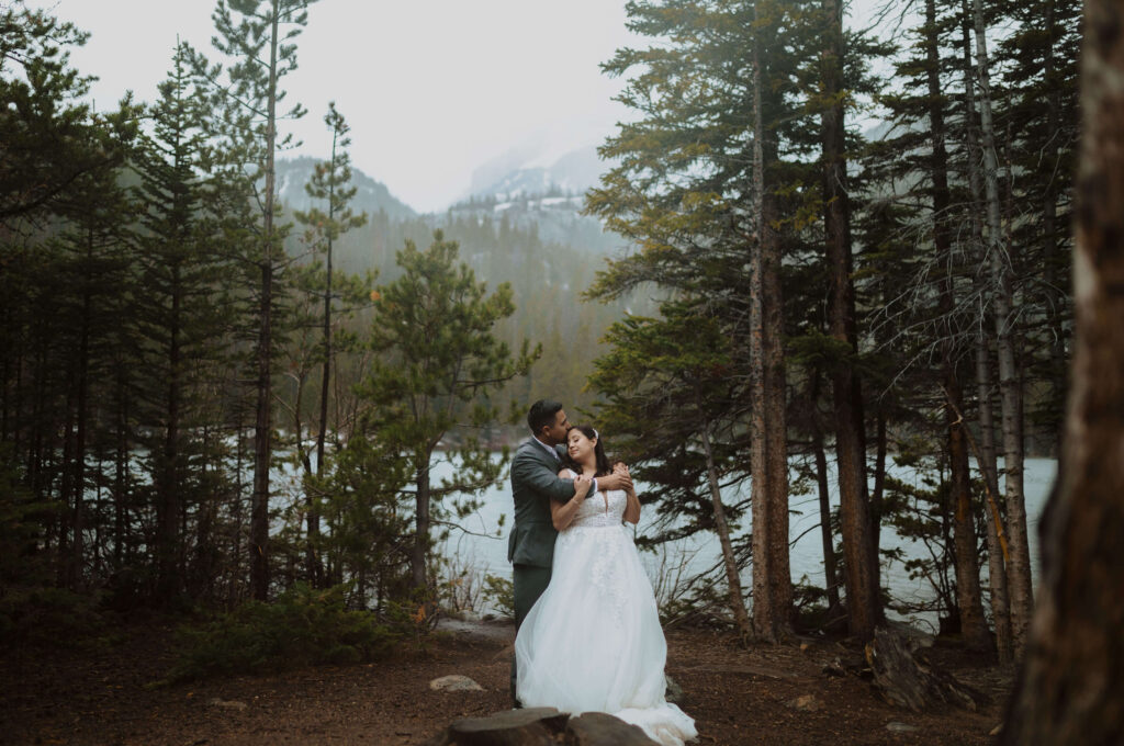 couple posing for Rocky Mountain Mountain National Park elopement surrounded by trees and mountains 