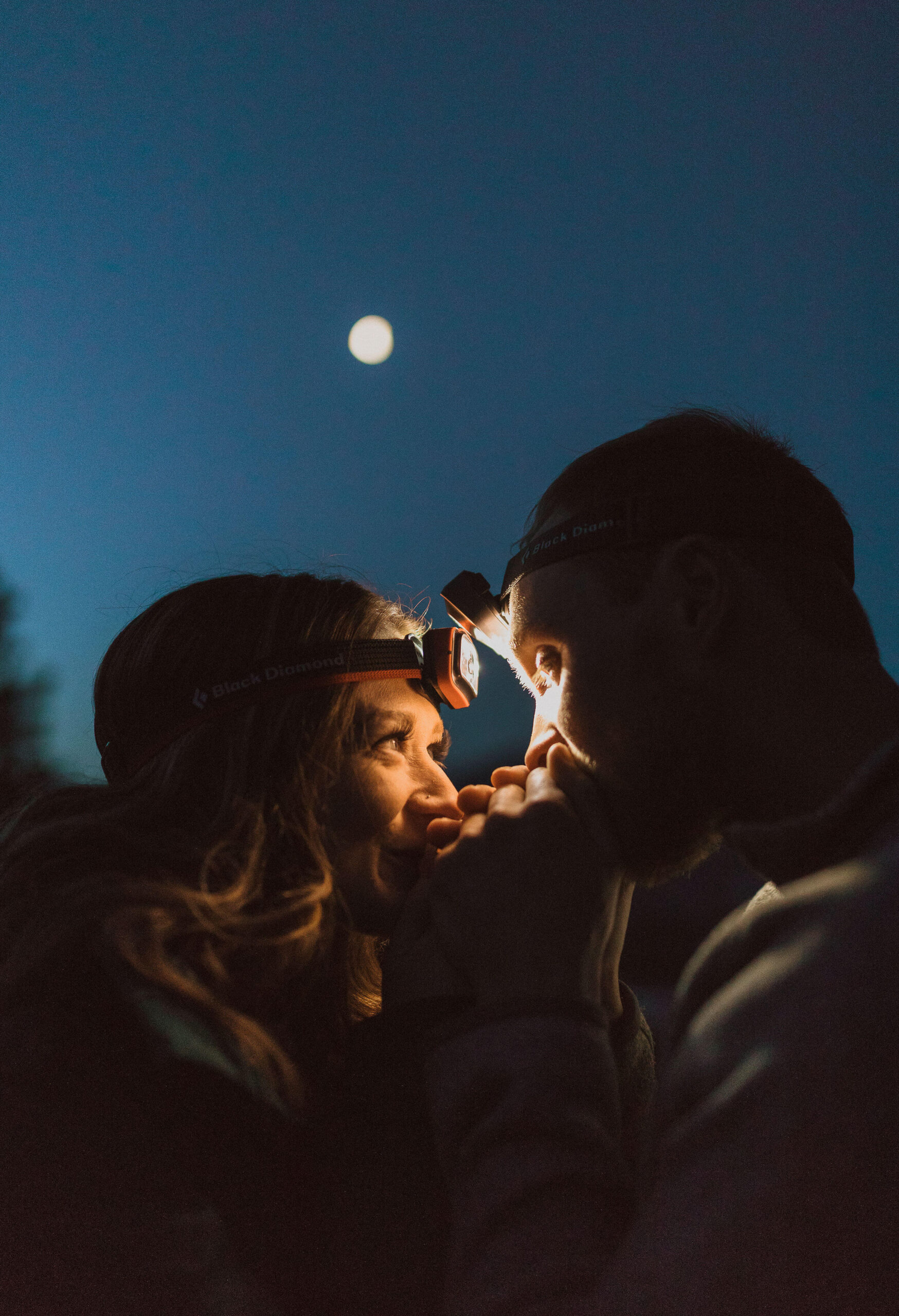 elopement couple looking at eachother in the dark with headlamps on