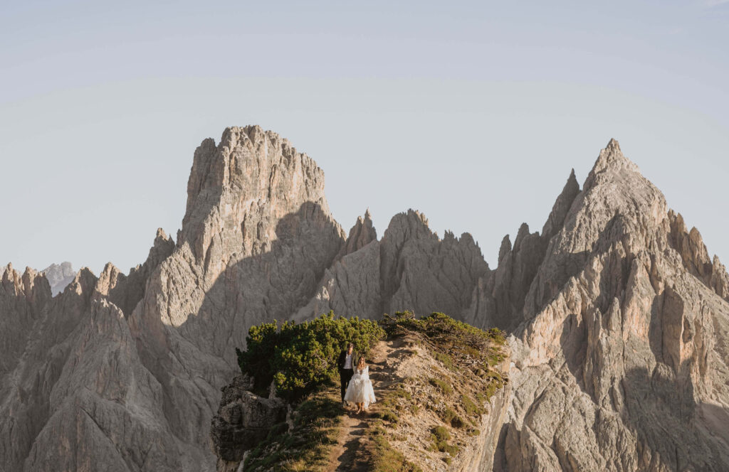 mountain peaks in the Dolomites with elopement couple walking far from camera