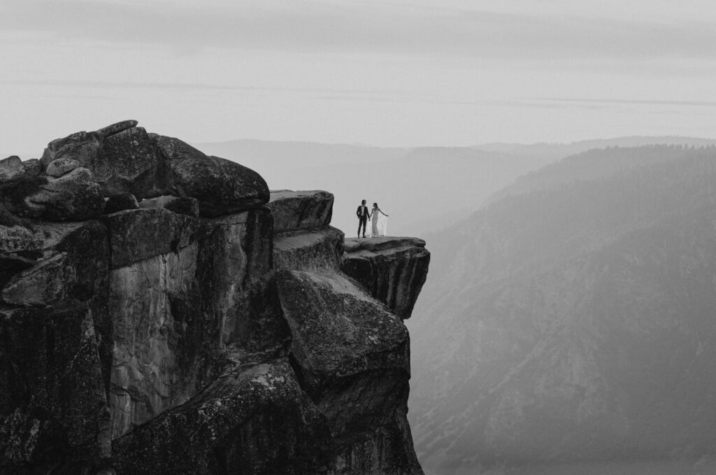 couple posing on cliff for affordable elopement in Yosemite National Park