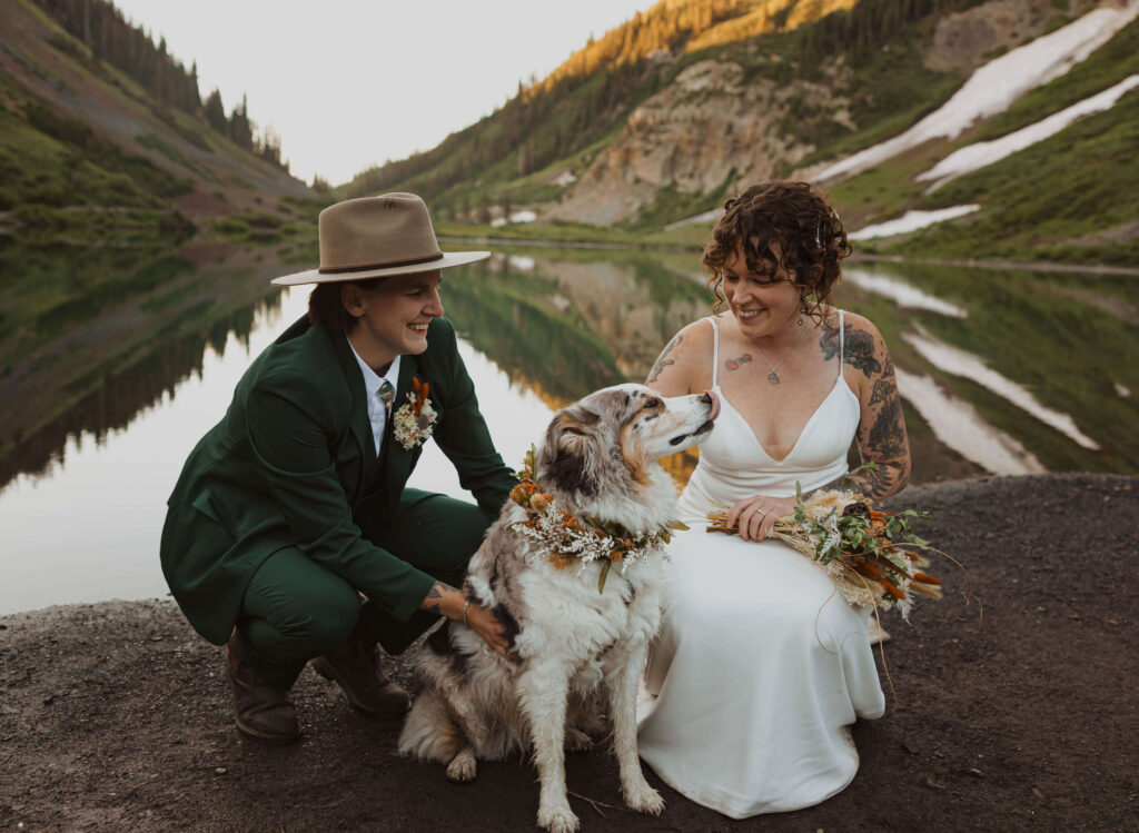 elopement couple looking at dog and smiling