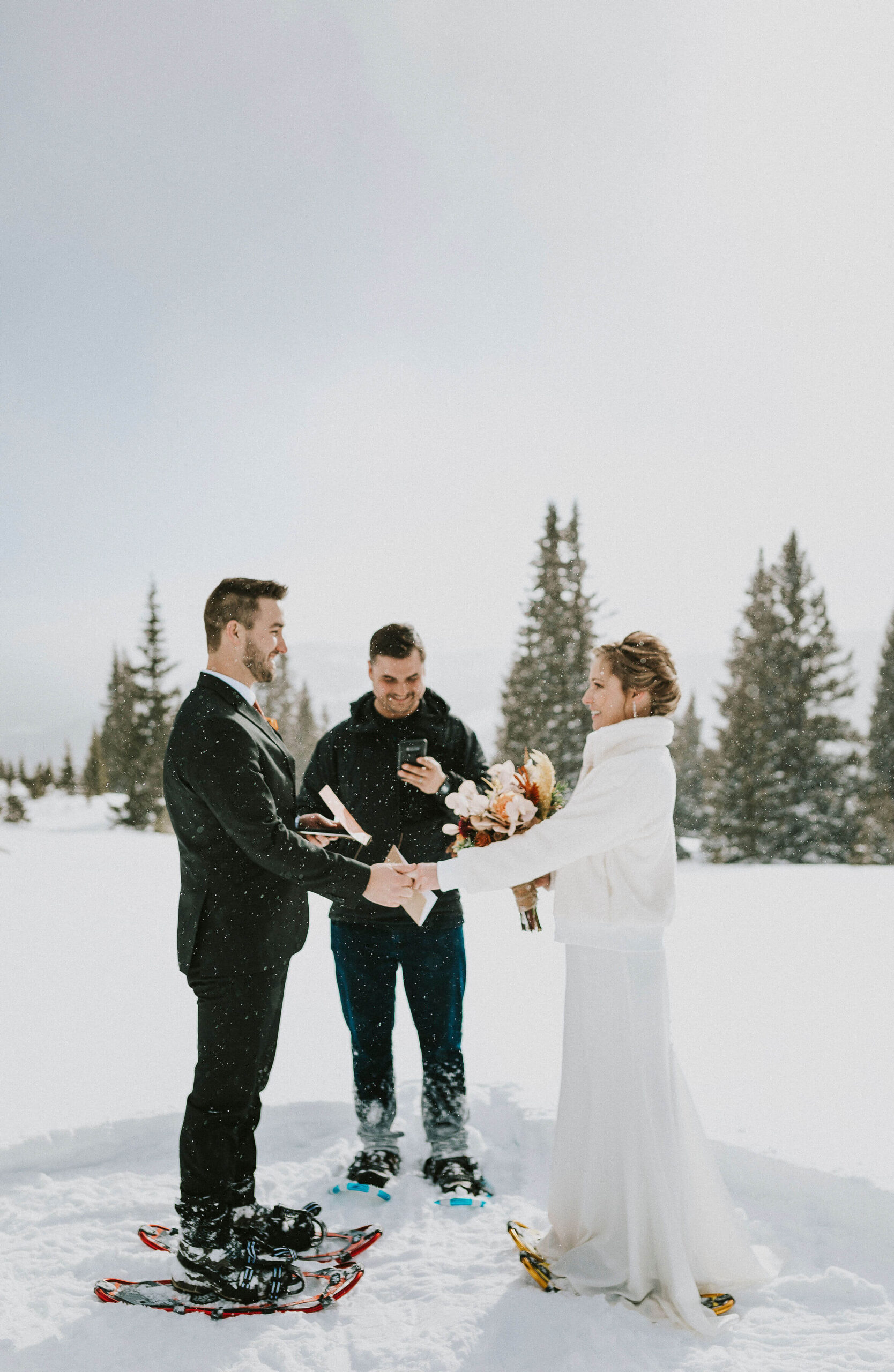 couple looking at each other for elopement vows surrounded by snow