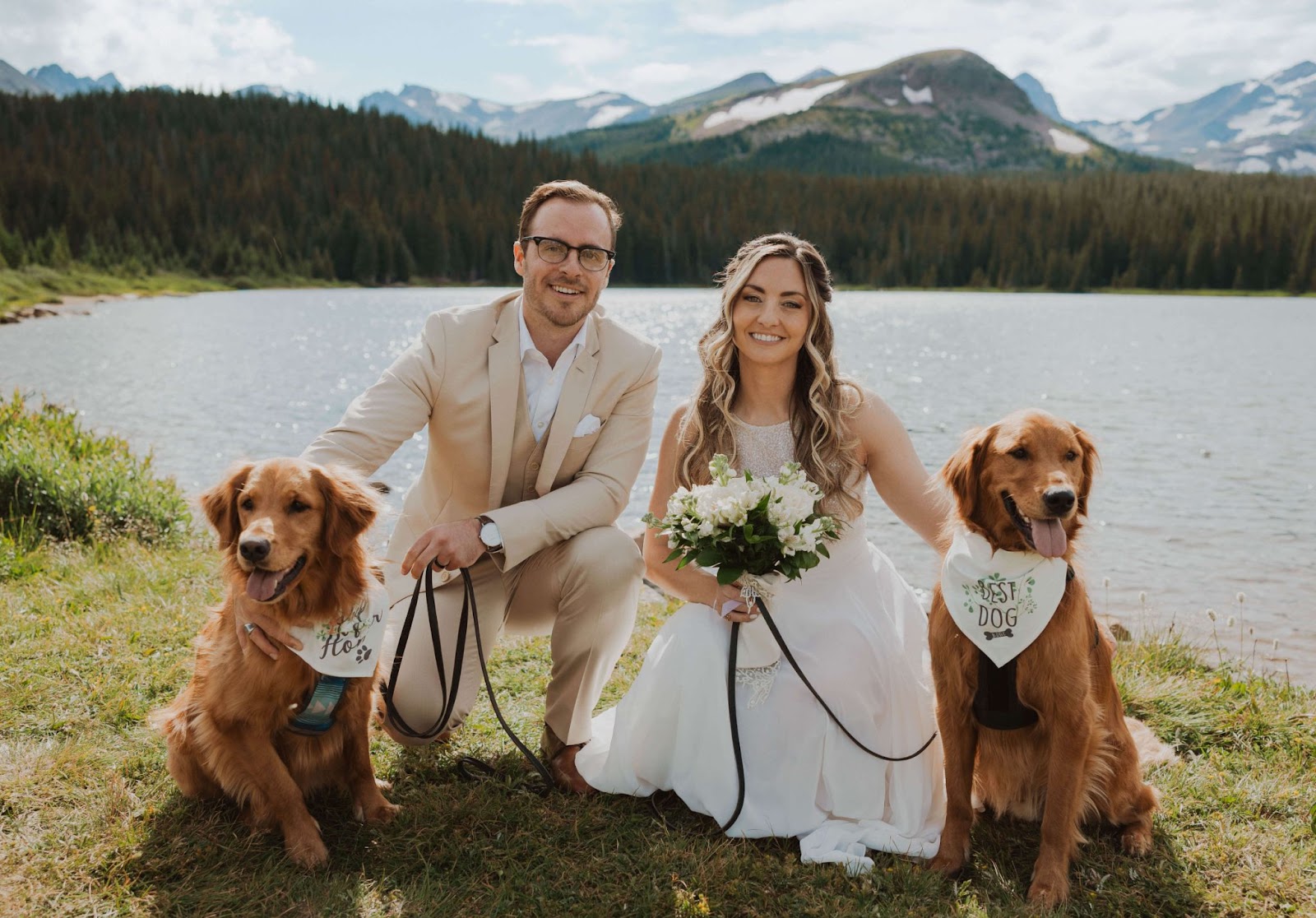couple posing with two dogs smiling at camera in front of Brainard Lake