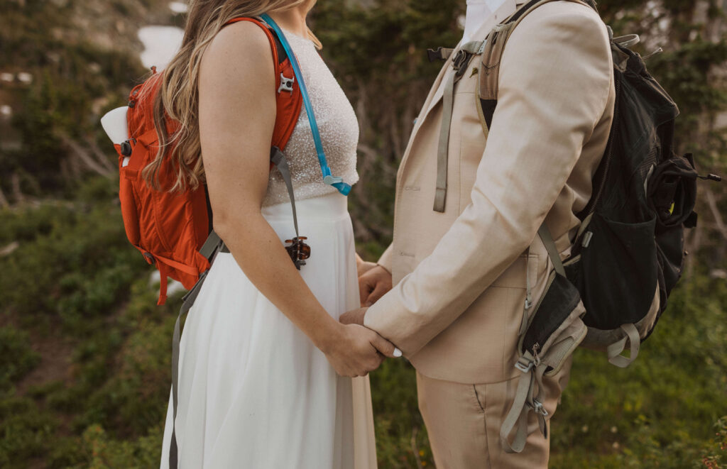 Bride and groom wearing backpacks for adventure elopement