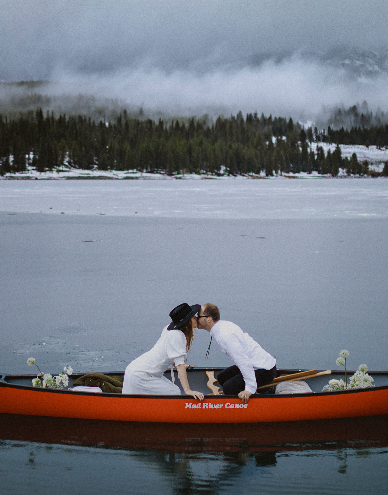 couple eloping in Montana in a kayak kissing