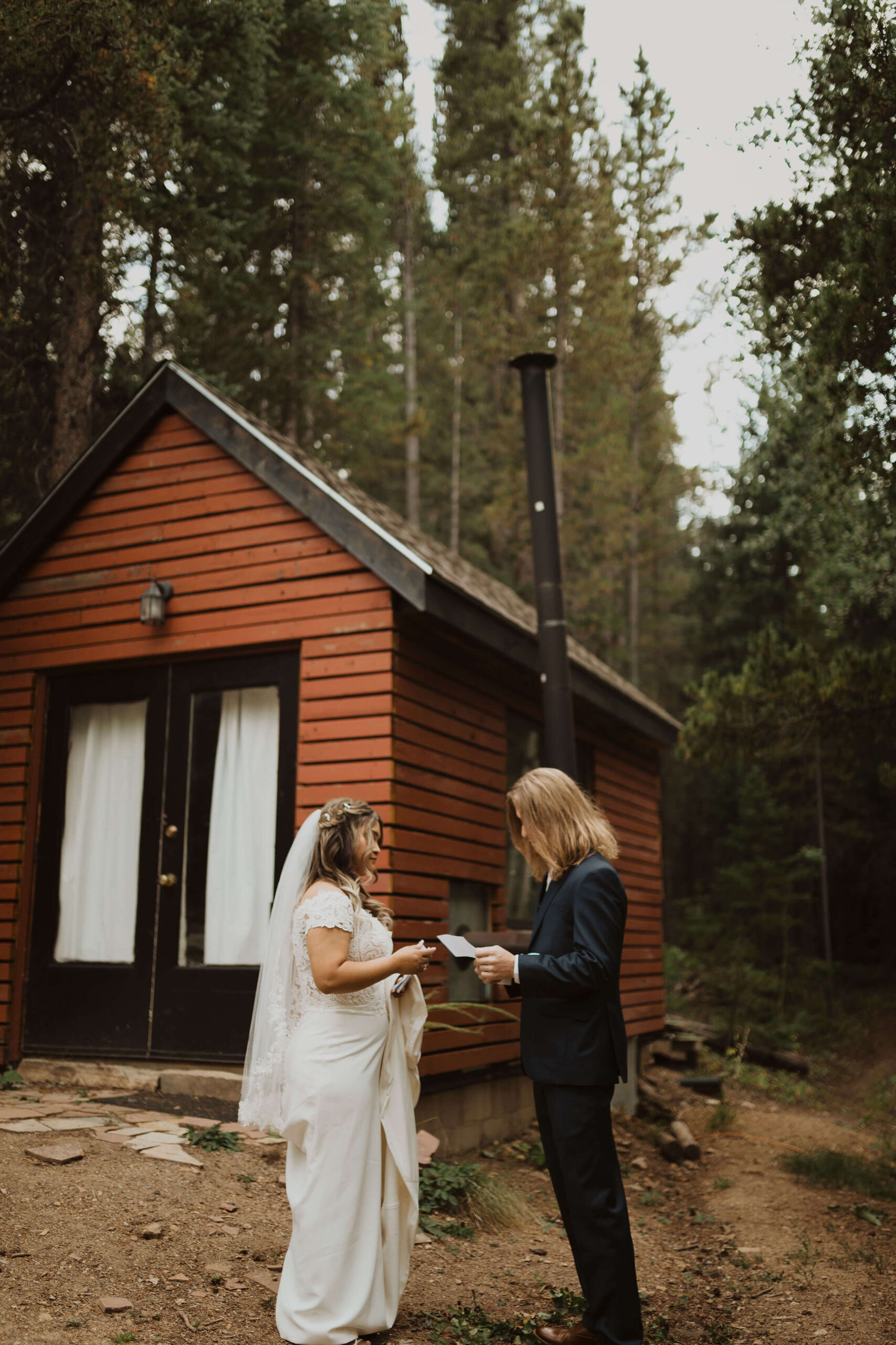 couple reading vows in front of cabin for Colorado micro wedding