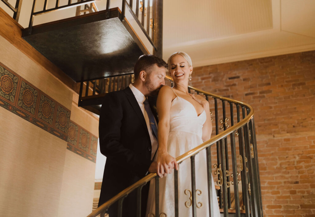 bride and groom posing on stairs at Beaumont Hotel and Spa in Ouray, Colorado
