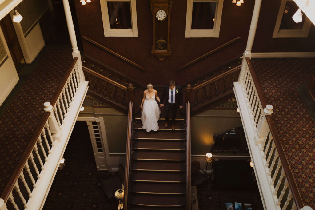 bride and groom posing on stairs at Beaumont Hotel and Spa in Ouray, Colorado