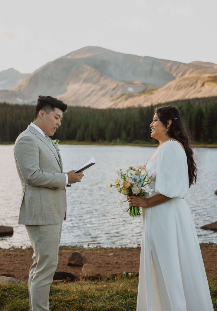 couple reading vows at Brainard Lake for outdoor wedding
