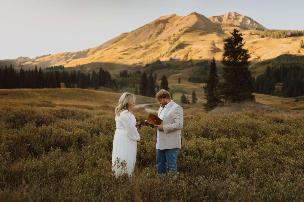 groom reading bride vows during wedding in Crested Butte, Colorado