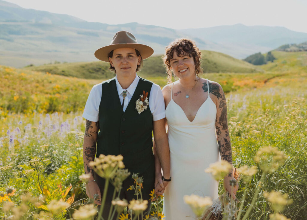 couple posing in a flower field in Crested Butte for elopement