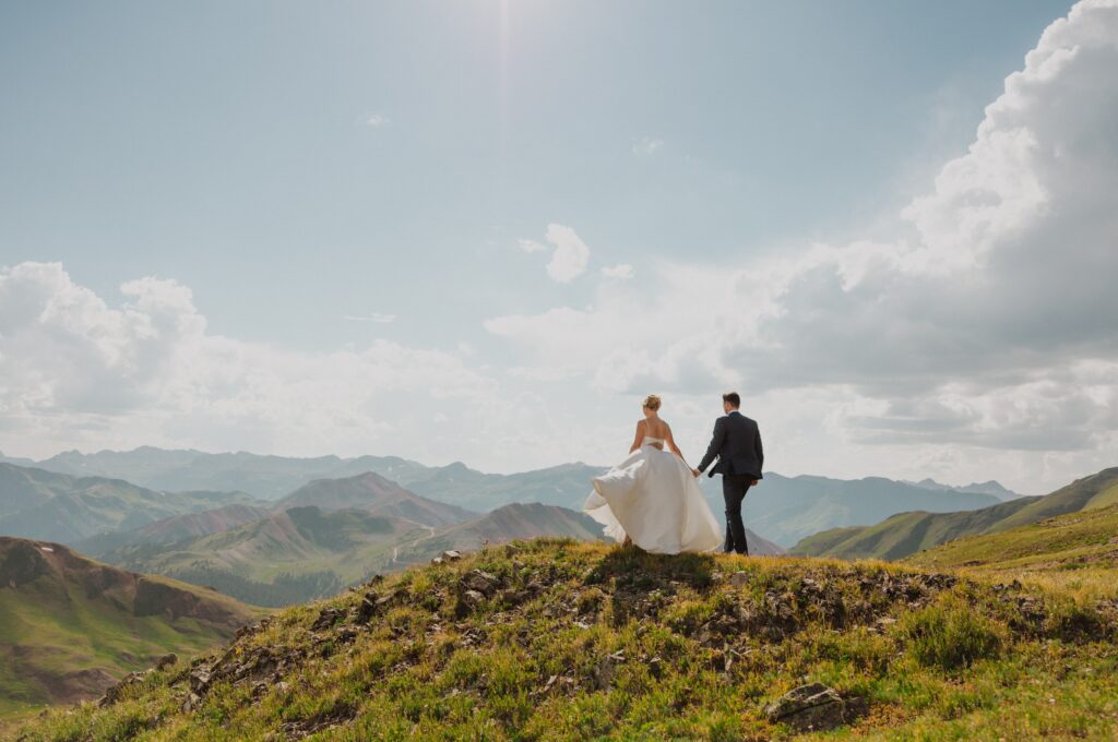 Bride and groom overlooking mountains for adventure elopement