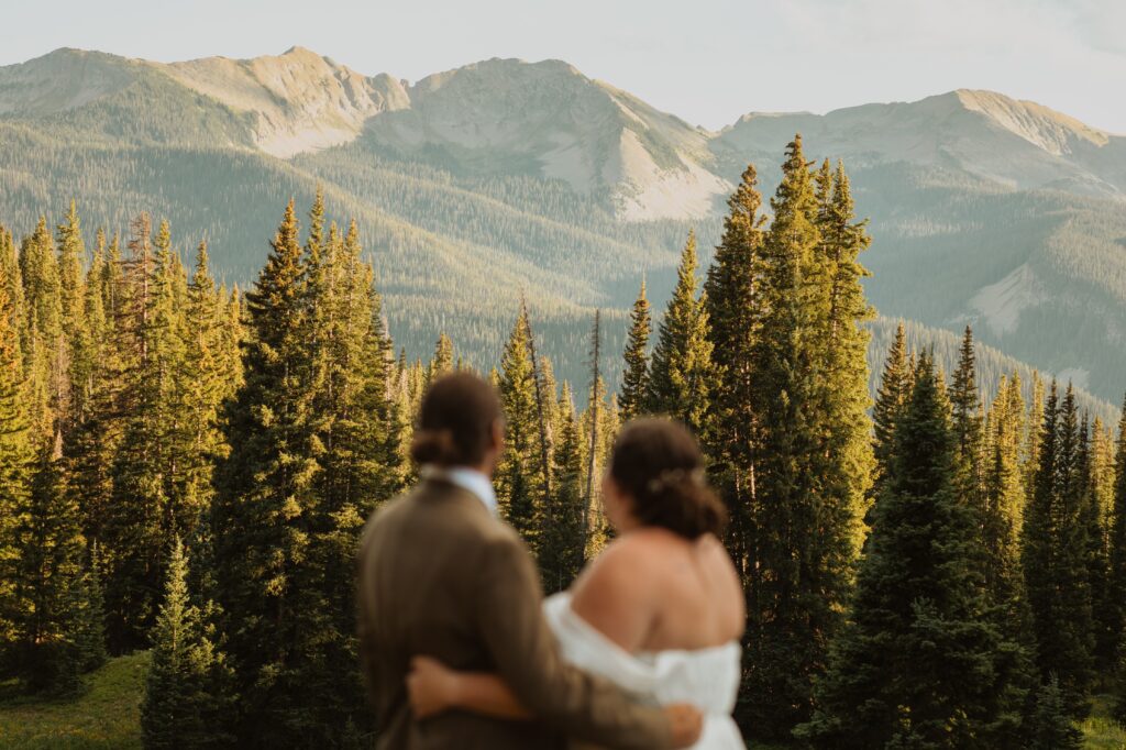 Bride and groom looking at mountains for adventure elopement photos