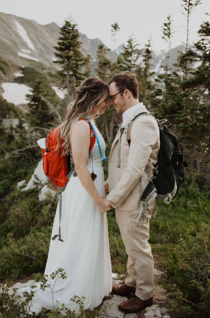 bride and groom with backpacks for camping wedding in Colorado