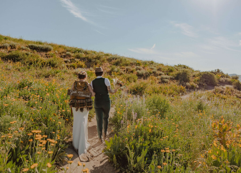 couple walking through wildflowers for elopement