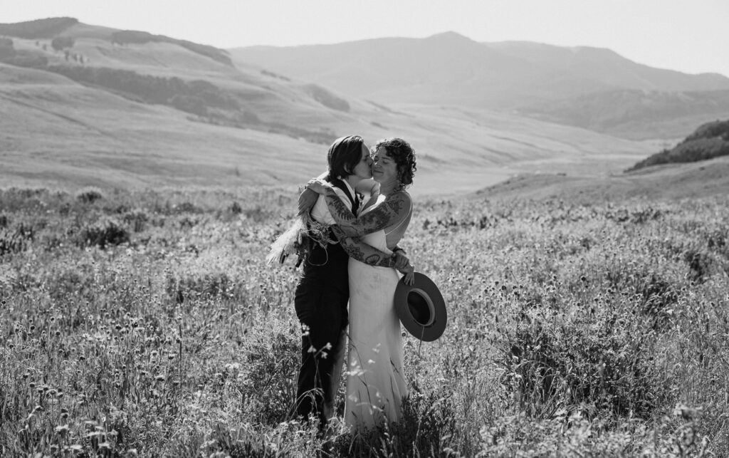 elopement couple hugging with mountain scenery in the background