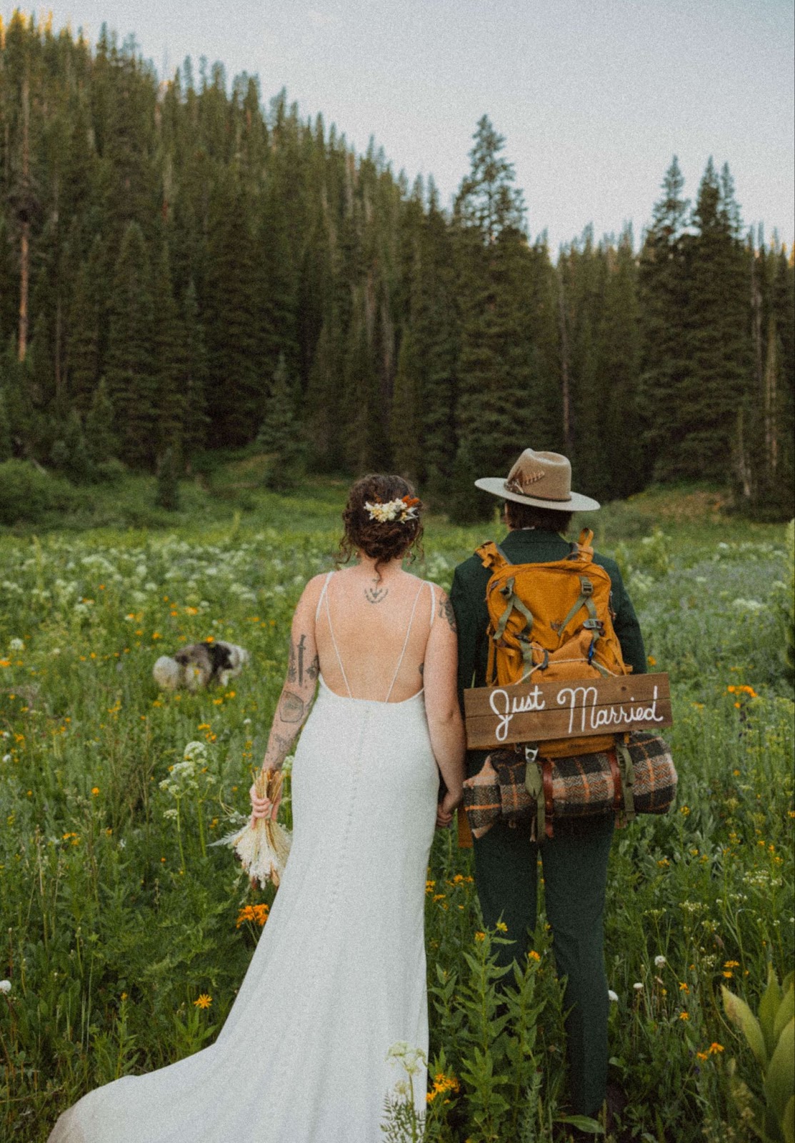 couple facing trees in flower field for elopement