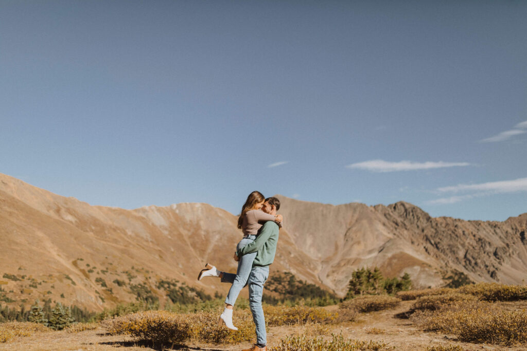 Couple hugging surrounded by scenery at Loveland Pass for engagement photos in Colorado