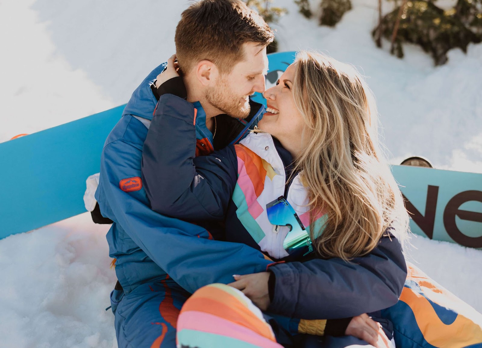 Couple smiling at each other in the snow for engagement photos in Colorado