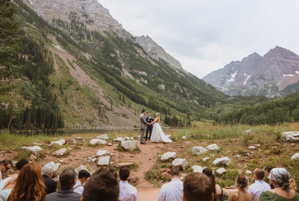 Bride and groom with guests at Maroon Bells for wedding ceremony