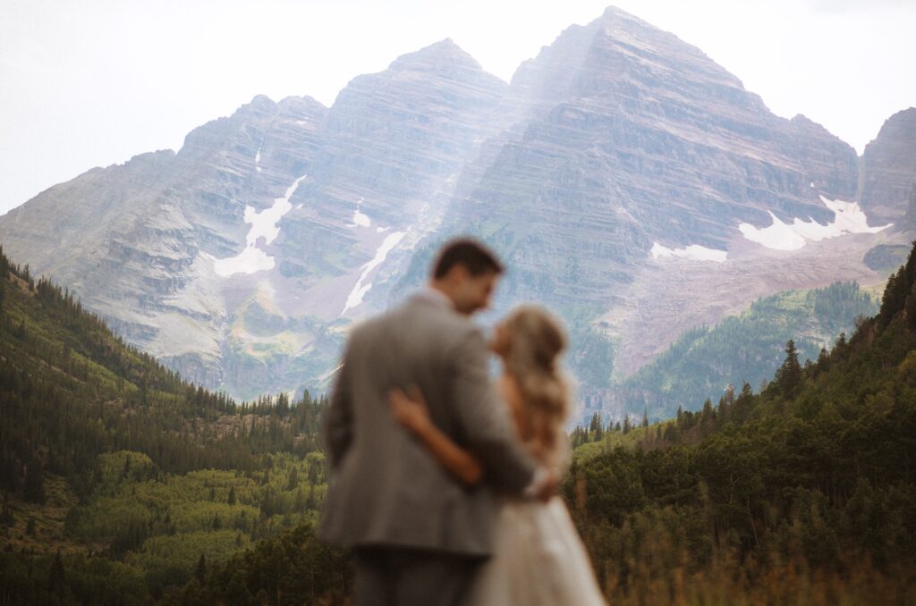 Bride and groom looking at each other posing for Maroon Bells wedding photo