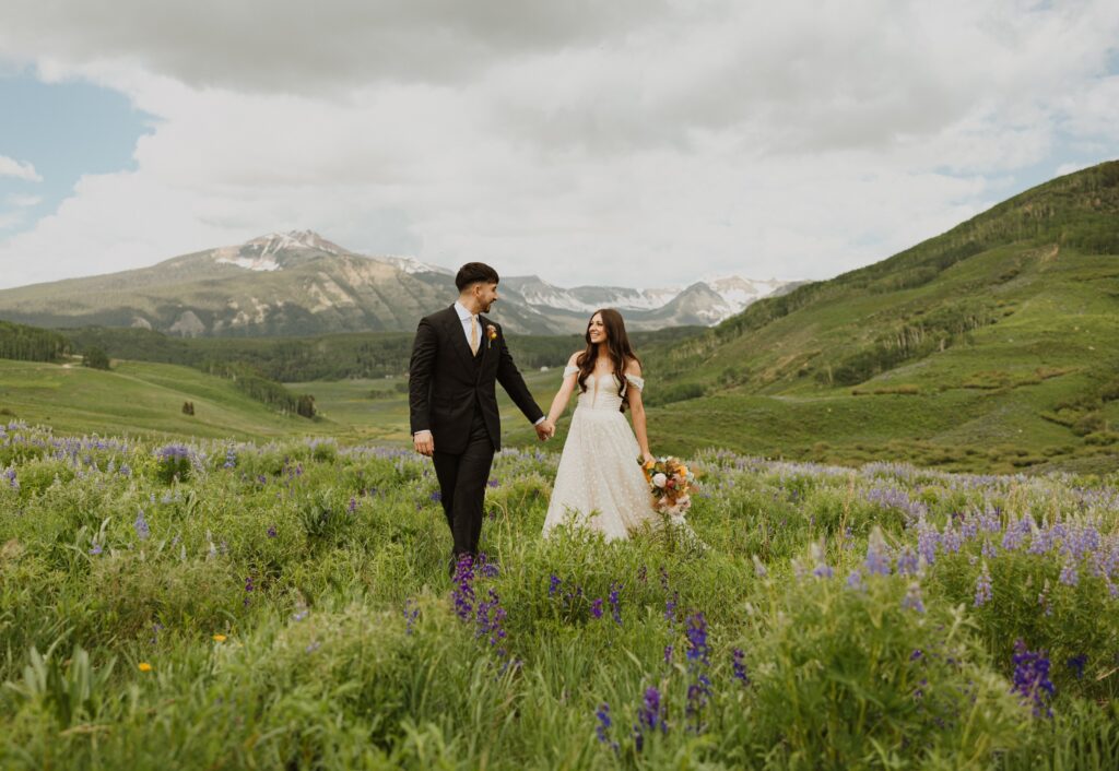 bride and groom surrounded by mountains and greenery in Crested Butte