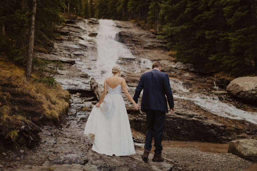 bride and groom facing waterfall in Ouray, Colorado