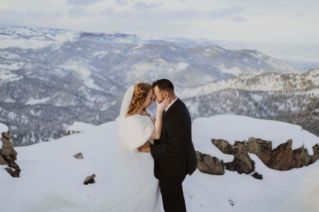 bride and groom surrounded by snow and mountain scenery in Boulder