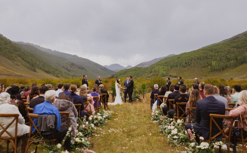 Couple at wedding ceremony with guests watching at Cement Creek Ranch