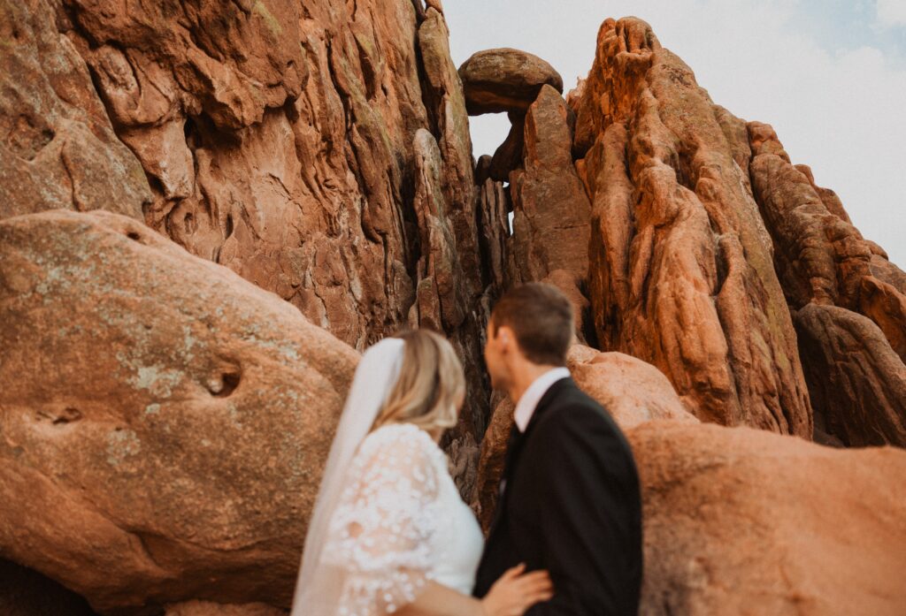 Bride and groom looking away at red rocks at Garden of the Gods