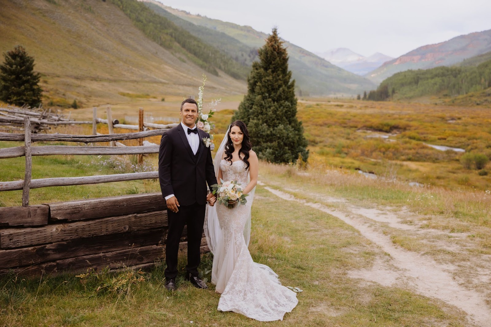 Bride and groom posing at smiling at camera at Cement Creek Ranch