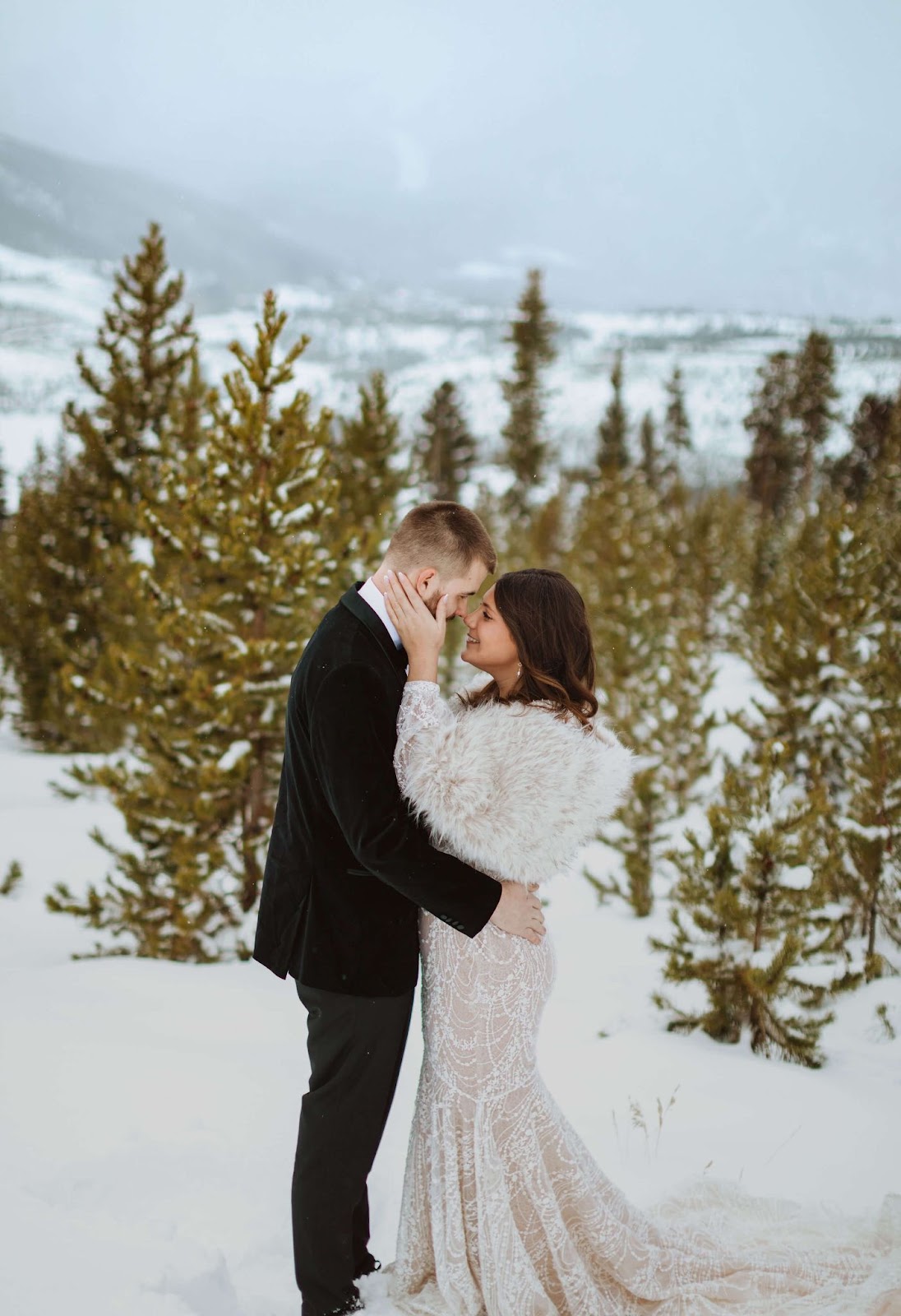 bride and groom embracing for Sapphire Point Overlook wedding photos surrounded by snow