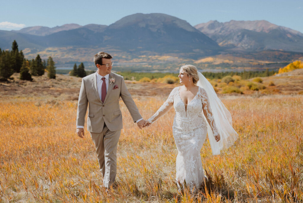 Bride and groom holding hands surrounded by fall scenery at Sapphire Point Overlook for wedding