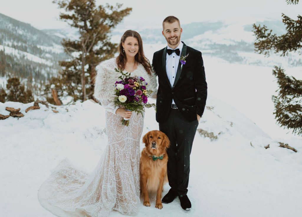 bride, groom, and dog posing for Sapphire Point Overlook wedding surrounded by snow