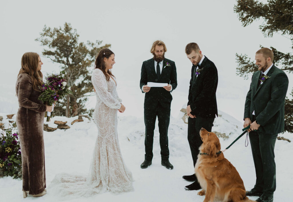 bride, groom, and dog at alter for wedding ceremony surrounded by snow