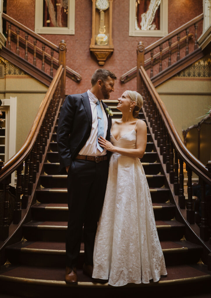 bride and groom posing on stairs at The Beaumont Hotel in Colrado