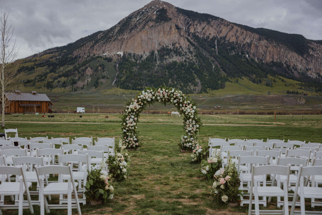 Town Ranch wedding venue in Colorado with arch, guests chairs, and mountain scenery