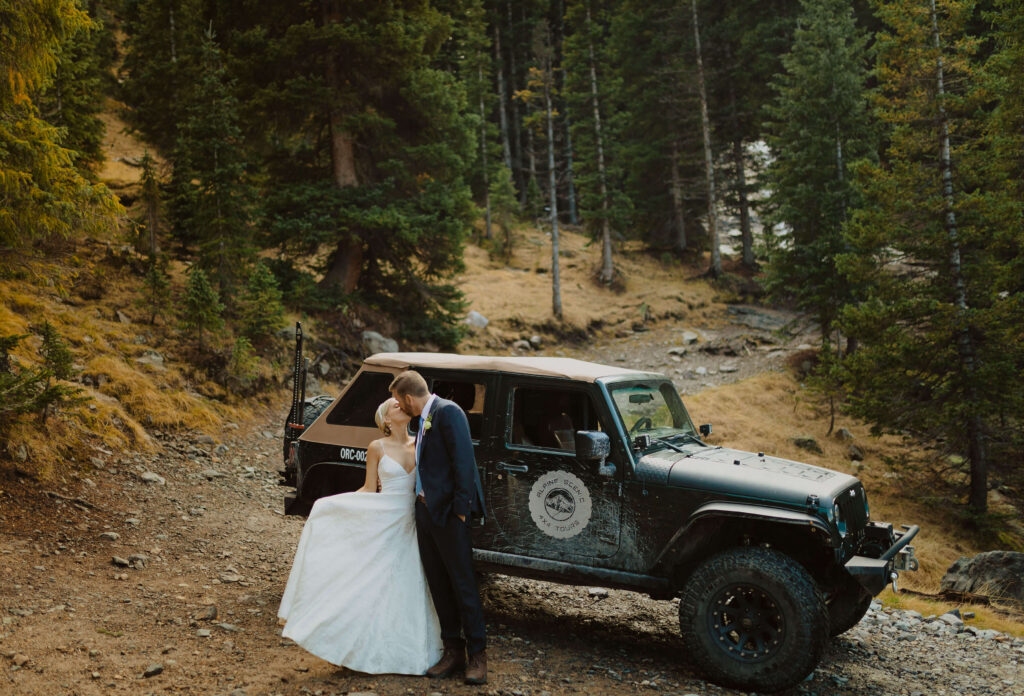 Bride and groom kissing by jeep for San Juan Mountains elopement